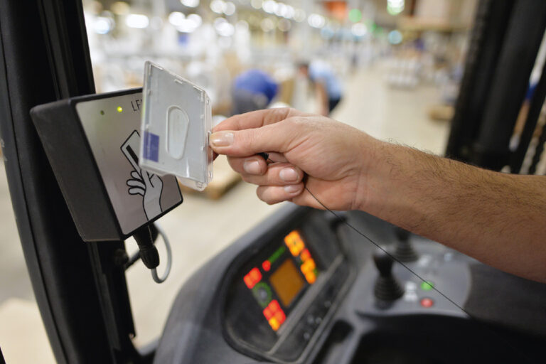 Ein Staplerfahrer hält eine elektronische Sicherungskarte von das Schloss des Staplers