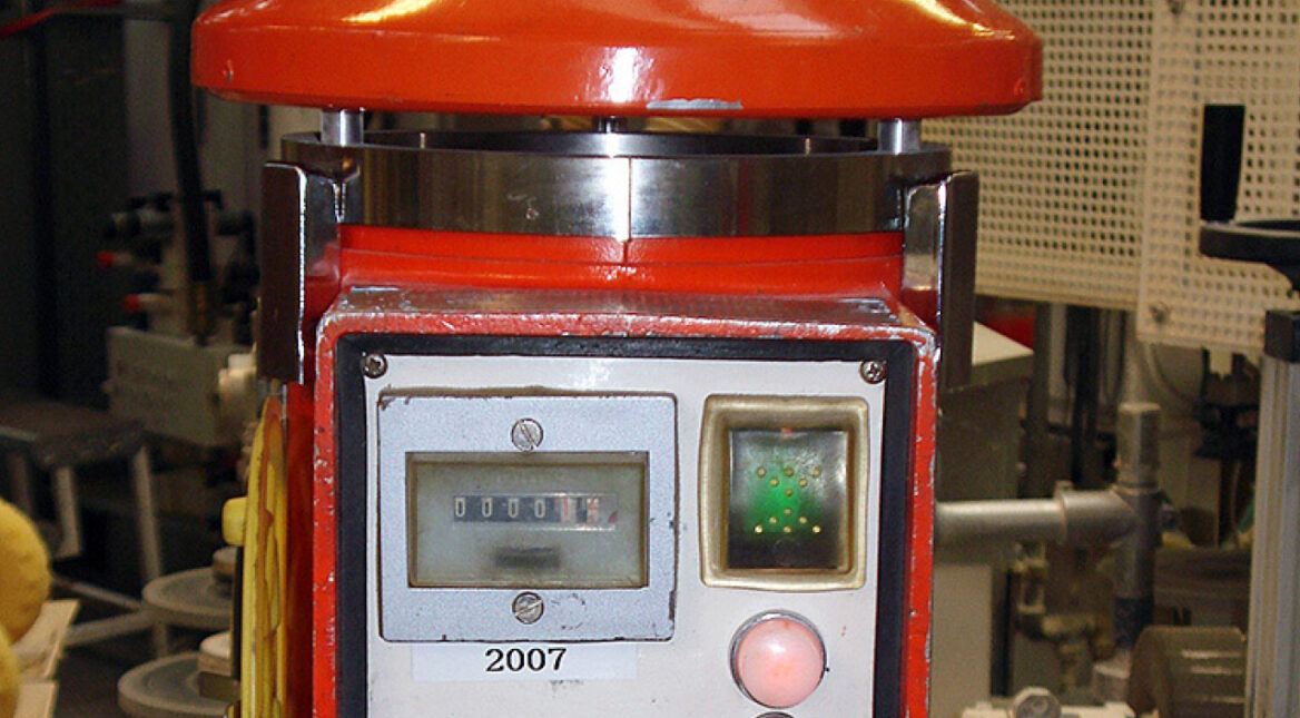 Ein rotes Messinstrument mit weißer Anzeige in einem Betrieb.