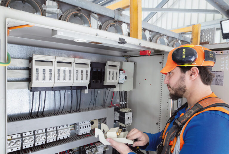 Elektriker bei der Arbeit an einem gesicherten Schaltkasten
