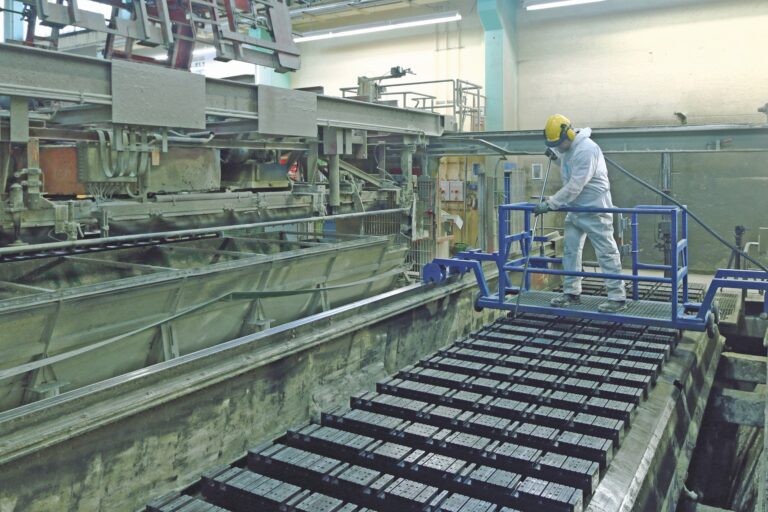 Ein Beschäftigter des Unternehmens Xella arbeitet in Schutzkleidung an einer Maschine